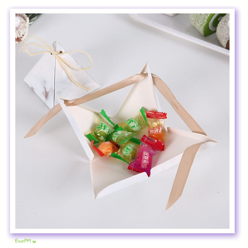 chic-pyramid-favor-box-ribbon-set.jpg Opened white pyramid favor box with pastel ribbons filled with assorted candies, exemplifying a stylish and sweet treat presentation.