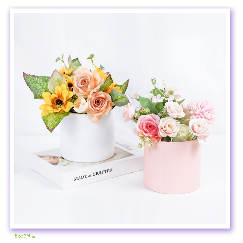 minimalist-flower-boxes.png Elegant white and pink minimalist flower boxes with a selection of beautiful artificial flowers, perfect for home or event decor.