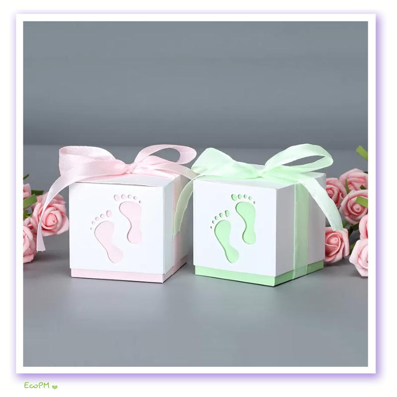 sweet-steps-baby-shower-favor-boxes-satin-ribbon.png Charming baby shower favor boxes with pink and mint green footprint cutouts and delicate satin ribbons, set against a background with soft-focus roses.