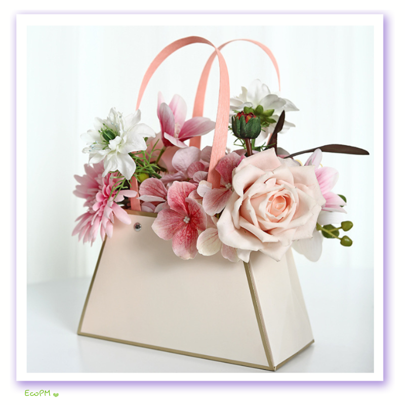 pastel-flower-arrangement-paper-bag.png Elegant pastel flower arrangement in a chic beige paper bag with pink handles.