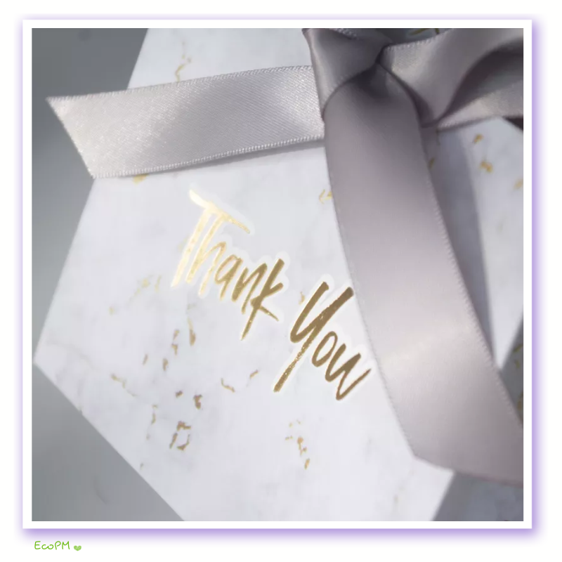 elegant-marble-thank-you-gift-box-satin-ribbon.png Close-up of an elegant white marble patterned gift box with golden 'Thank You' text and a silver satin ribbon