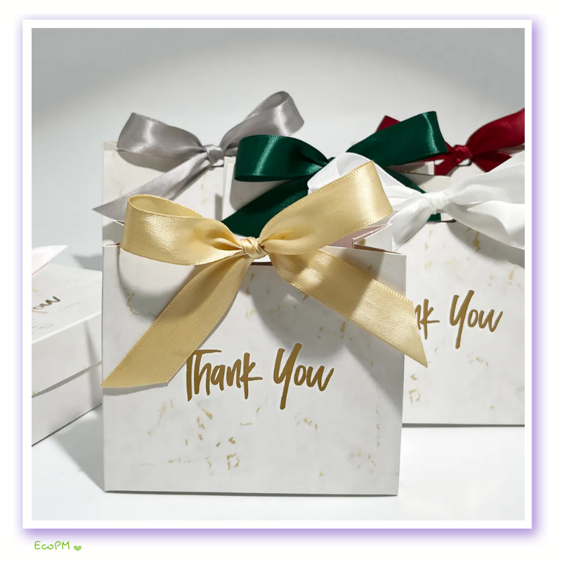 luxurious-marble-effect-thank-you-gift-boxes-with-satin-ribbons.png Elegant white marble-patterned gift boxes with golden 'Thank You' inscription and satin ribbons in various colors.
