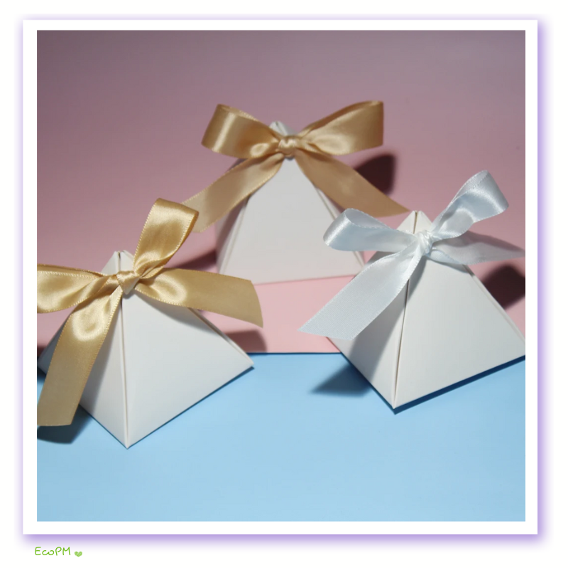 pastel-gift-boxes-satin-ribbons.png Elegant white pyramid gift boxes with golden and silver satin ribbon bows on a pastel blue and pink background.
