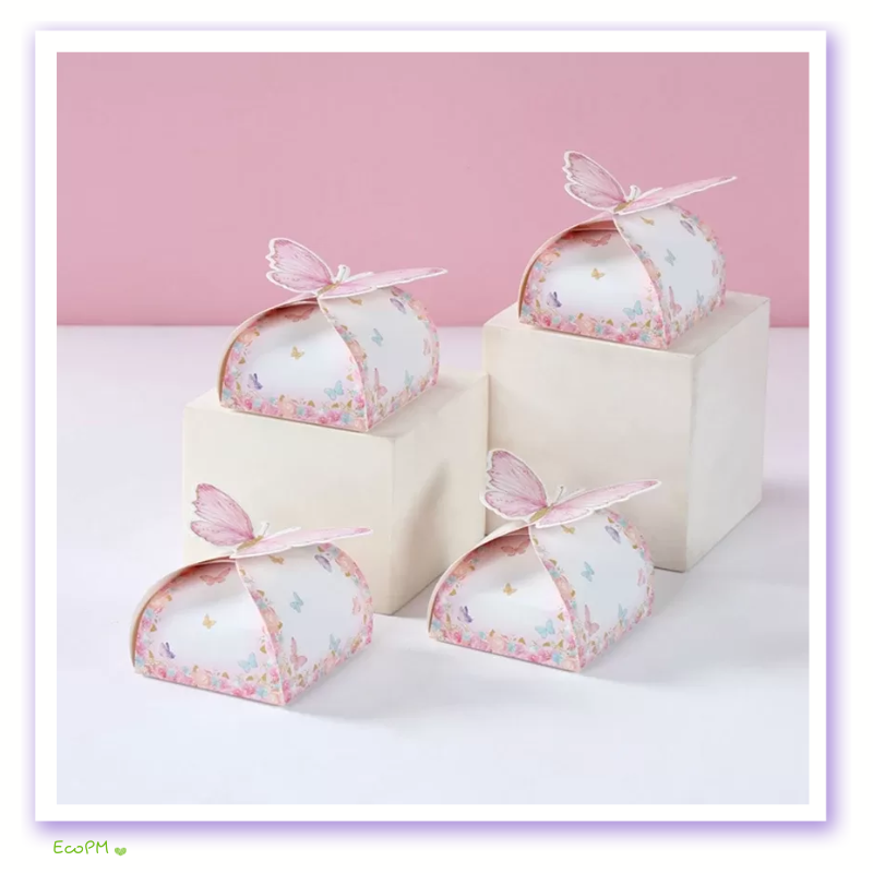 butterfly-floral-candy-boxes-collection.png Four floral candy boxes with delicate butterfly toppers arranged on and around neutral-toned blocks against a pink background.