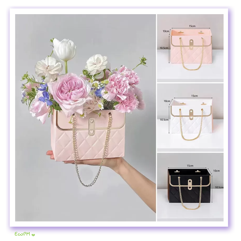 chic-pink-flower-box-with-gold-chain-handle.png Elegant pink flower box with a stylish gold chain handle, adorned with a lush arrangement of roses and peonies.
