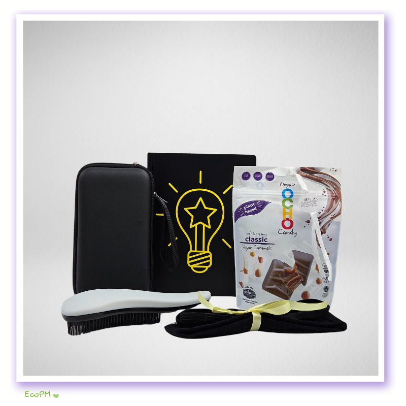 eco-conscious-desk-essentials-kit.jpg Sustainable office essentials with lightbulb notebook, vegan caramels, and black accessories.