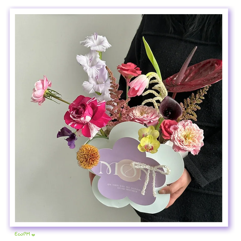 mothers-day-floral-display-box.png Mother's Day flower box featuring a variety of fresh blooms in a uniquely shaped paper container with a