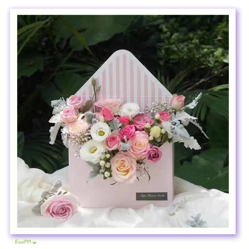 pastel-floral-envelope-box.png Pastel pink envelope-style flower box with a delicate arrangement of roses and wildflowers