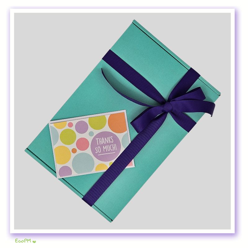 azure-wellness-collection-packaged-gift-box.jpg Elegant teal gift box with a purple ribbon and a colorful thank you card.