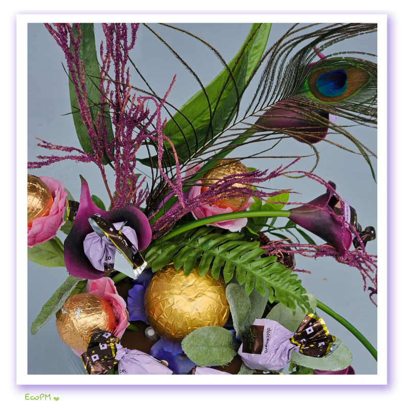elegant-enchantment-chocolate-arrangement-closeup.jpg Close-up of the Elegant Enchantment Chocolate Arrangement highlighting premium chocolates and a peacock feather.