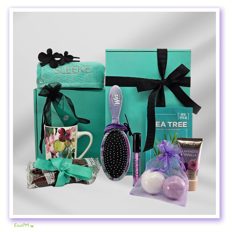 turquoise-tranquility-wellness-box-unboxed-display.jpg Comprehensive spa gift set featuring a hair care kit, tea tree face mask, hand cream, and floral mug with organic treats.