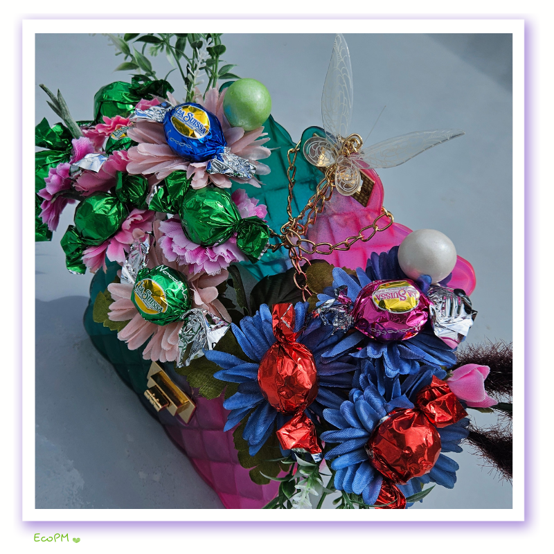eco-party-floral-chocolate-bag-closeup-1.png Close-up of eco-friendly floral bag with colorful chocolates and butterfly